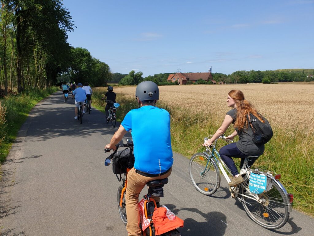 Menschen per Fahrrad unterwegs in der Natur - wirkt positiv auf psychische Gesundheit