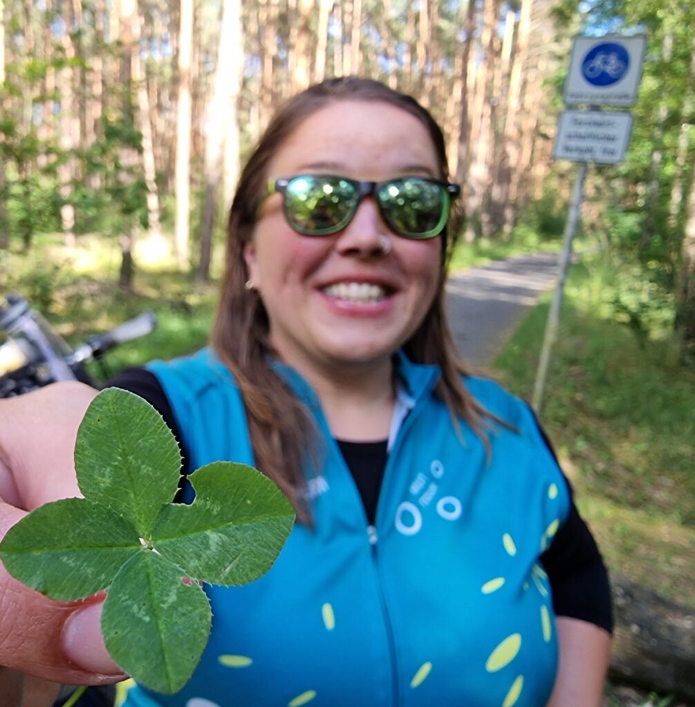 Mensch mit Kleeblatt in der Hand
